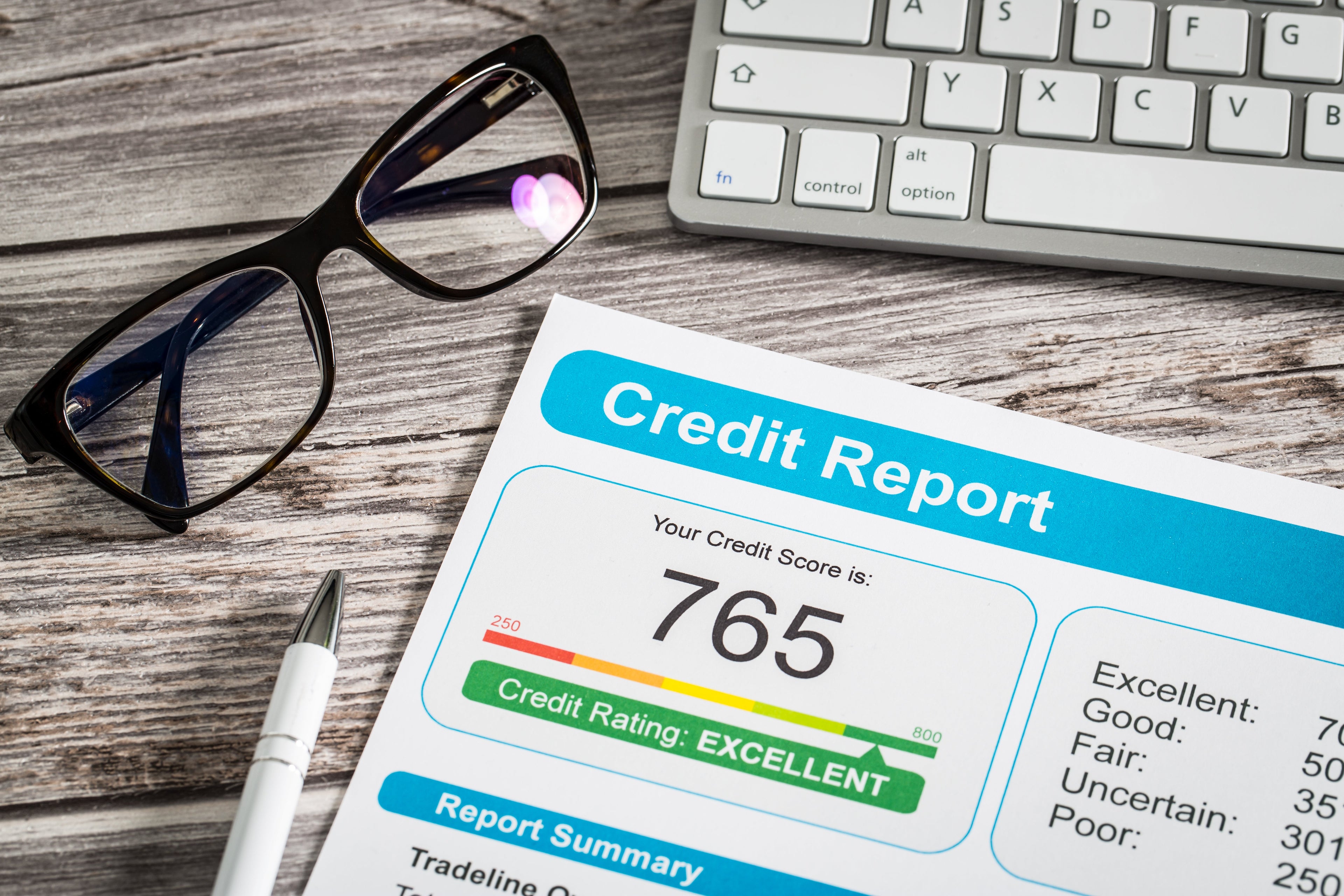 A pair of glasses positioned next to a credit report